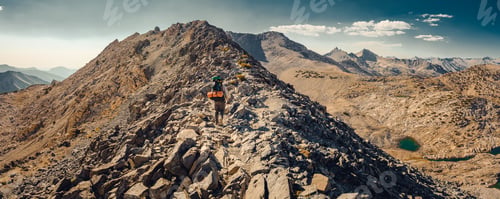Preview: Man hiking among an exotic alpine backcountry wilderness