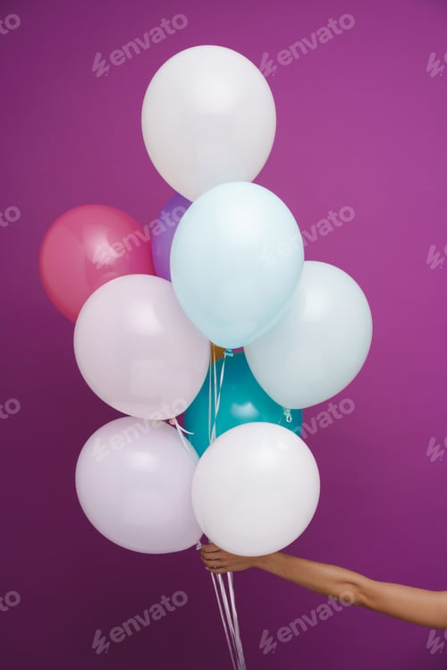 Preview: Photo of woman's hand showing multicolored balloons