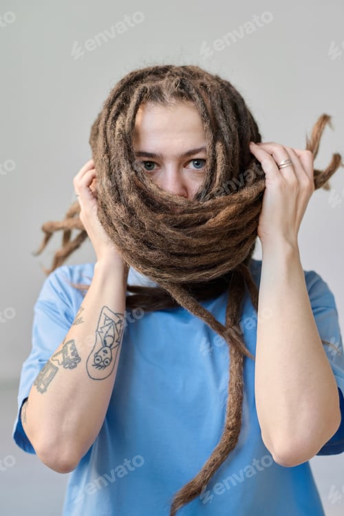 Preview: Woman with Long Dreadlocks Wrapping Face with Hair