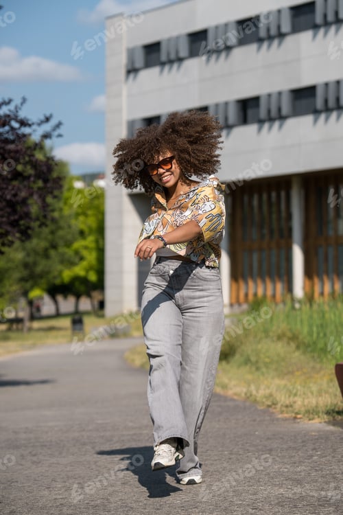 Preview: Young woman walking and smiling in urban park