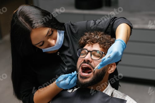 Preview: Dentist checking patient teeth during oral examination