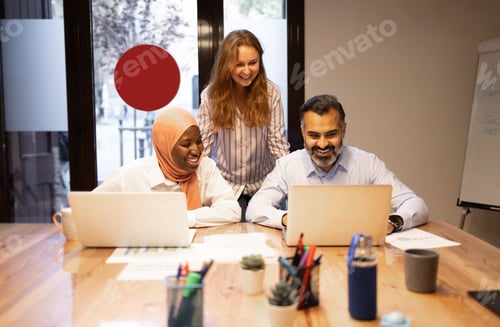 Preview: Diverse colleagues working with laptops in modern office during business meeting