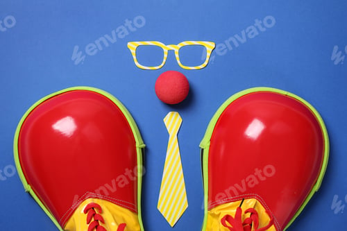 Preview: Flat lay composition with shoes, paper glasses, nose and tie on blue background