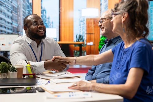 Vista previa: Experto financiero que comparte un apretón de manos con una anciana clienta