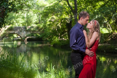 Preview: young handsome guy with a girl hugging in the summer outdoors in the forest