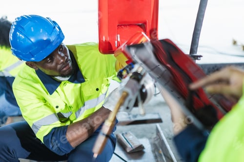 Preview: Male american african technician automation robotics arm at industrial modern factory.