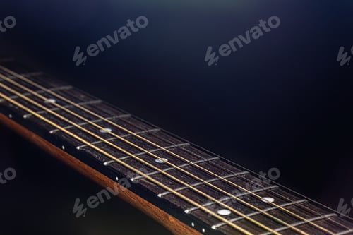 Preview: Close-up of strings on the fretboard of an acoustic guitar.