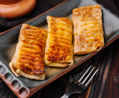 Preview: Fried pancakes twisted with meat inside on a plate