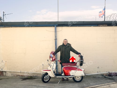 Preview: Portrait of mature male mod with moped in front of wall