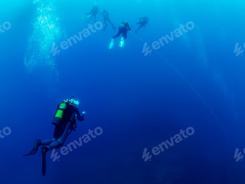 Preview: scuba divers in wetsuit making the safety stop