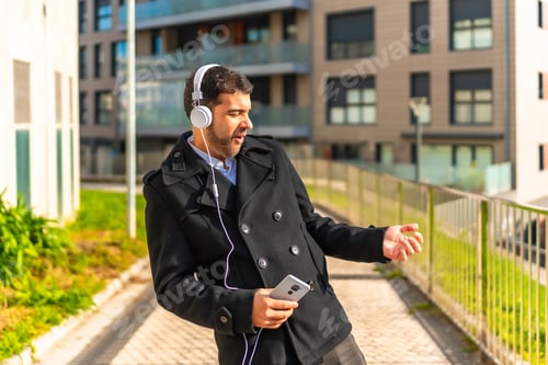 Preview: Casual businessman dancing while listening to music in the city