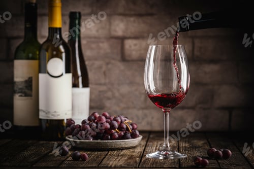 Preview: Red Wine in a Glass with Bottles and Grapes