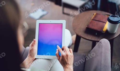 Preview: Unrecognizable female remote worker browsing internet on tablet