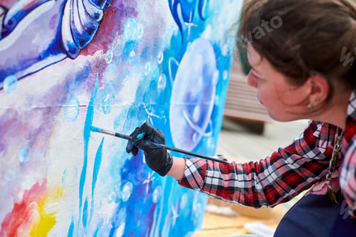 Preview: Female painter draws picture with paintbrush on canvas for outdoor street exhibition