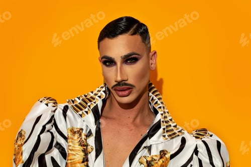 Preview: Portrait of beautiful drag queen model with yellow background