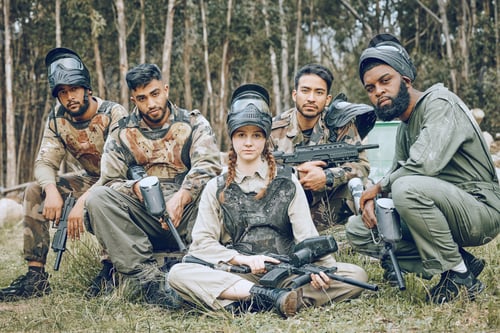 Preview: Paintball, portrait or team in a shooting game playing or training on a fun battlefield in nature.