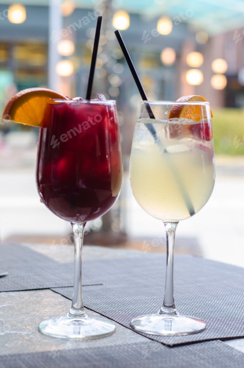Preview: Refreshing Drinks with Orange Garnish on Table