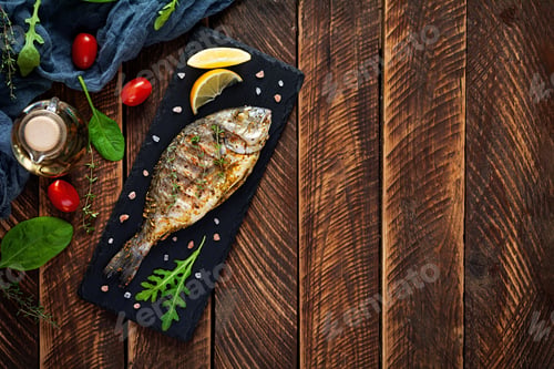 Preview: Grilled dorado fish on wooden background. Roasted seafish with spice and herbs