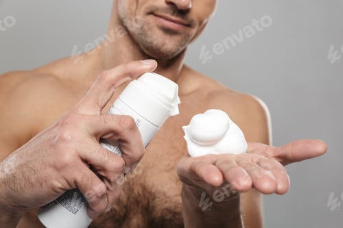 Preview: Mature man standing isolated with shaving cream.