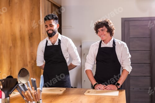 Preview: Cooking course - senior male chef in cook uniform teaches young people cooking class students to