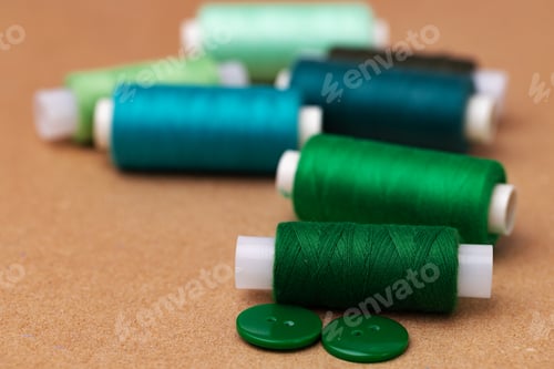 Preview: Thread spools and buttons on beige background