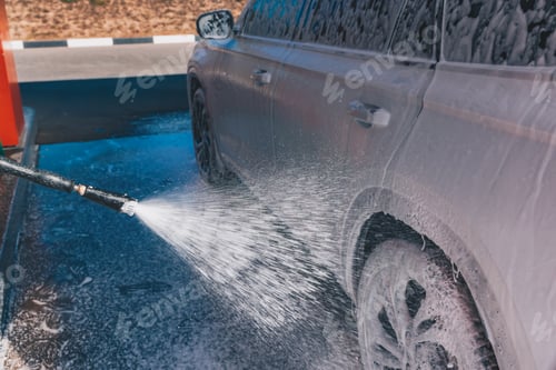 Preview: Сar wash self-service. Man washing luxury vehicle with white foamy detergent.