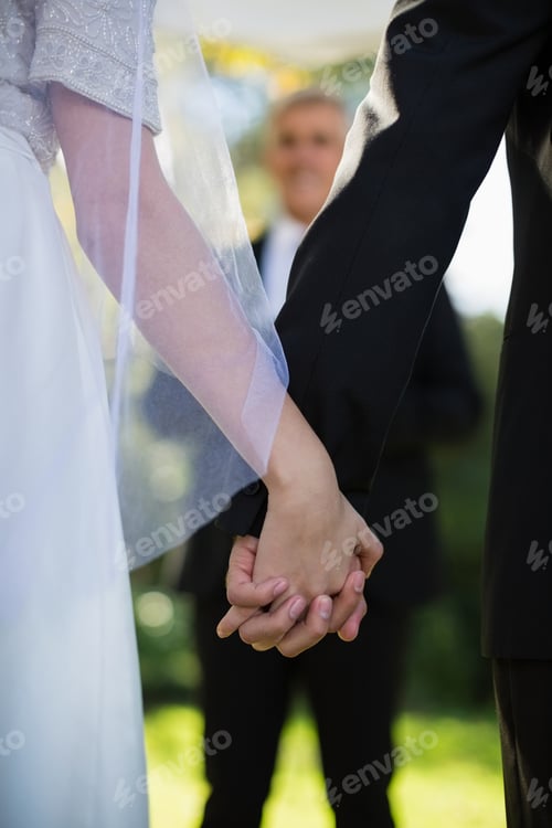 Preview: Mid section of couple holding hands