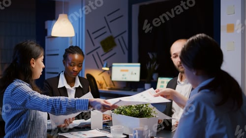Preview: Diverse multiethnic businesspeople sharing management graphs paperwork overworking in office meeting
