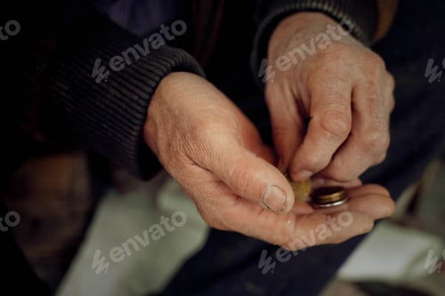 Preview: Hands Holding Coins in a Dark, Moody Setting