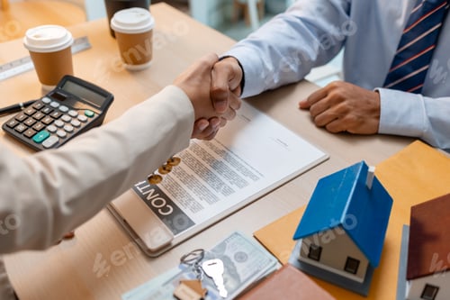 Preview: A real estate agent and a client are shaking hands after signing a house purchase agreement.