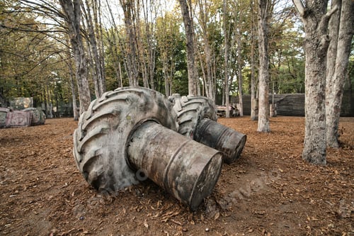 Preview: Old rusty barrels and damaged tires on a paintball base