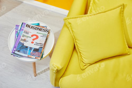 Preview: close up of yellow sofa with pillows and coffee table with business magazines