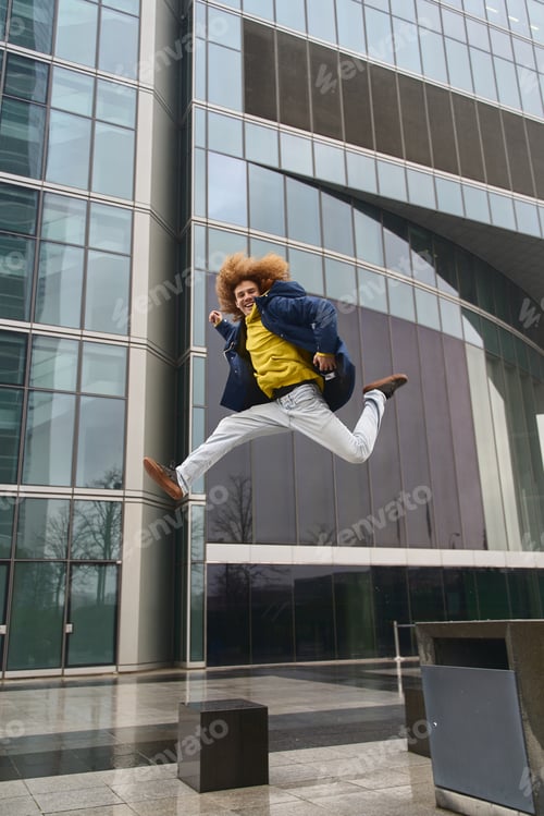 Preview: Energetic businessman jumping in urban setting