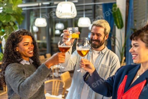 Preview: Multi-ethnic friends raising glasses and celebrating success at night party