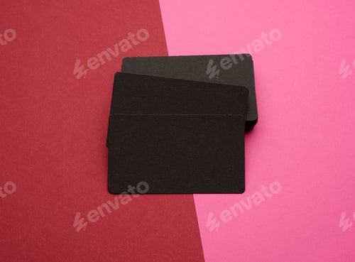 Preview: Stack of rectangular black paper blank business cards on pink red background