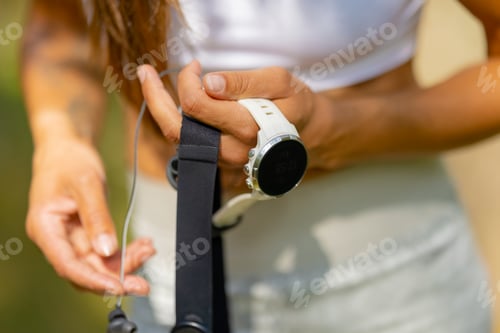 Preview: Close-up of woman using fitness smart watch device and chest strap heart rate monitor under workout
