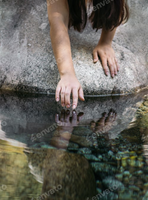 Preview: Close up of a hand touching the water of the river