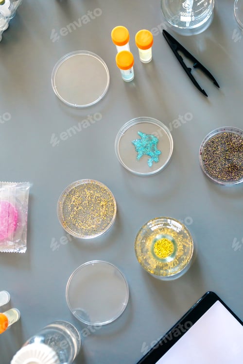 Preview: Laboratory instrument set and glitter samples in petri dishes over a lab table background