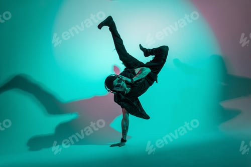 Preview: Handsome stylish dancer cool man in fashionable clothes dancing in colorful studio