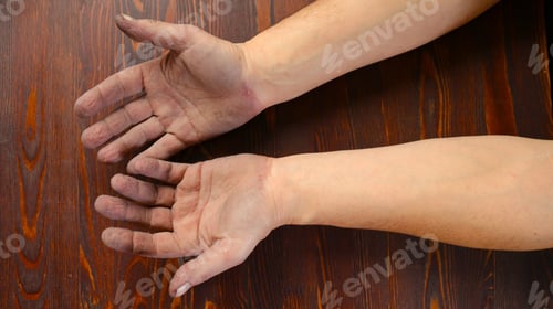Preview: men's rough hands up to the elbows on a wooden surface