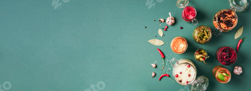 Preview: Assortment of various fermented and marinated food over green background, copy space. Top view