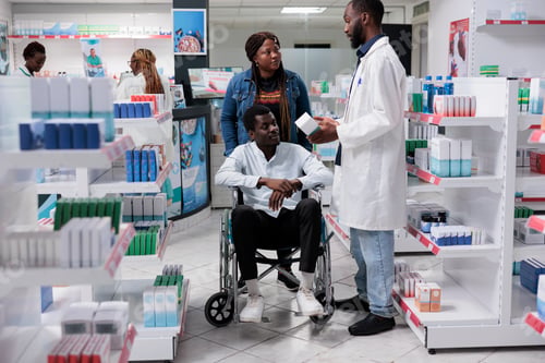Preview: Man in wheelchair and social worker choosing prescription treatment