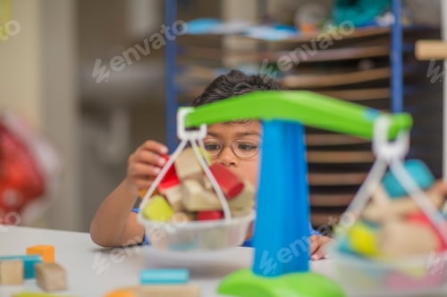 Preview: Boy playing with toy scales in kindergarten