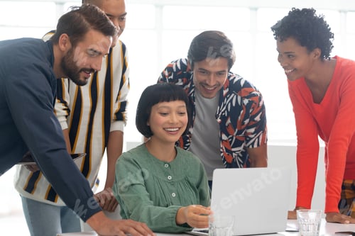 Preview: Front view of diverse business people discussing over laptop in the conference room at office