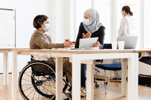 Preview: Three women in face mask discussing project while working at office