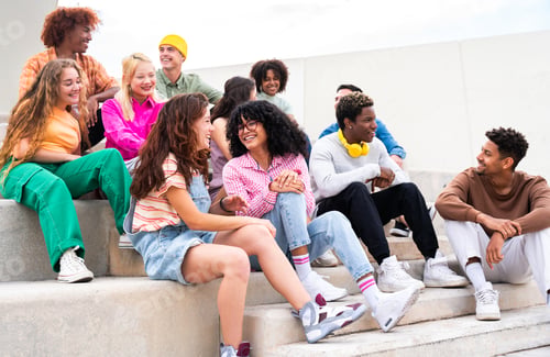 Preview: Happy playful multiethnic group of young friends bonding outdoors
