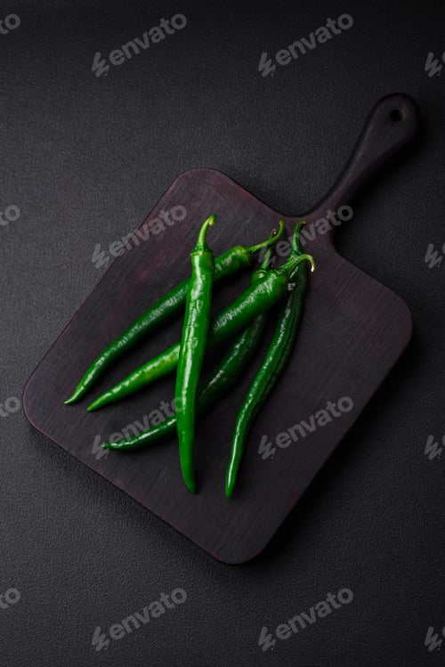 Preview: Fresh hot green chili peppers on a dark concrete background