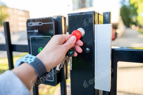 Preview: Hand with house keys opening magnetic lock on gate