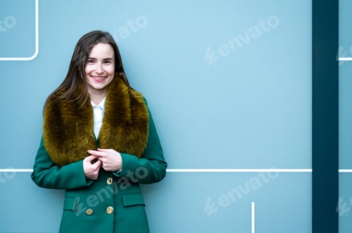 Preview: portrait of an elegantly dressed business woman near a blue wall of a modern office building