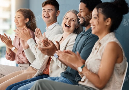 Preview: Group of cheerful businesspeople clapping while sitting in a row in a meeting together. Happy busin